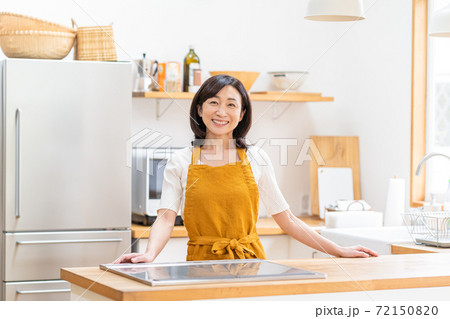 キッチンに立つ笑顔のミドル女性 キッチンに立つ笑顔のミドル女性 72150820