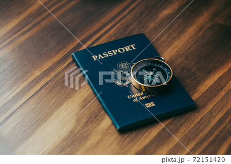 One gold compass on top of a blue American passport 72151420