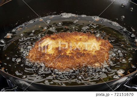フライパンと少量の油でトンカツを揚げるの写真素材