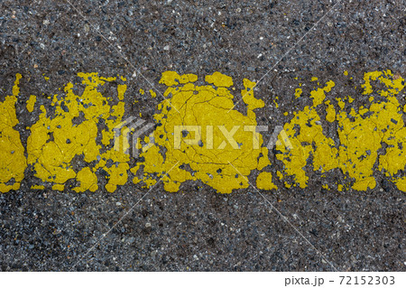 Old painted yellow line on asphalt road. Abstract texture background. Old painted yellow line on asphalt road. Abstract texture background. 72152303