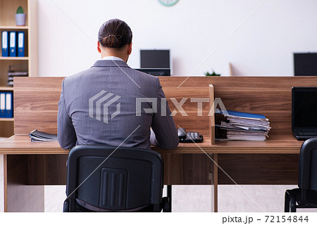 Young male employee working in the office Young male employee working in the office 72154844