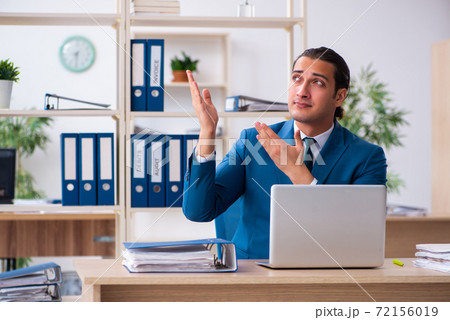 Young handsome employee sitting in the office Young handsome employee sitting in the office 72156019
