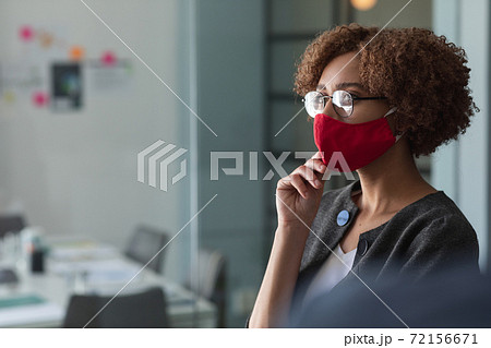 Mixed race woman wearing mask in an office Mixed race woman wearing mask in an office 72156671