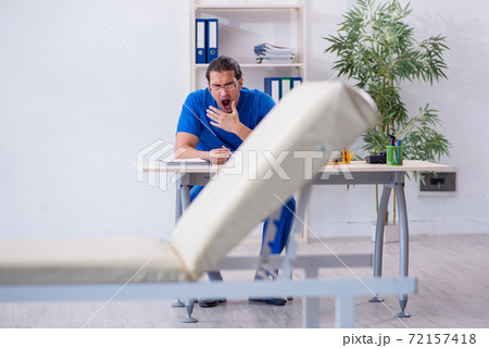 Young male doctor being extremely tired in the clinic Young male doctor being extremely tired in the clinic 72157418