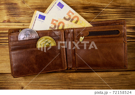 Wallet with fifty euro bills and bitcoins on wooden background 72158524