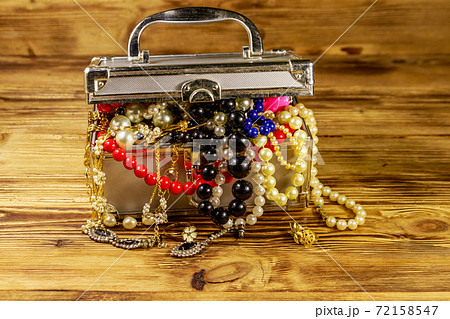 Jewelry box full of jewelry and accessories on wooden background Jewelry box full of jewelry and accessories on wooden background 72158547