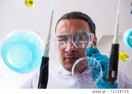 Young male chemist working in the lab 72158739
