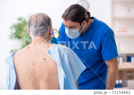 Old man visiting young male doctor dermatologist 72158962