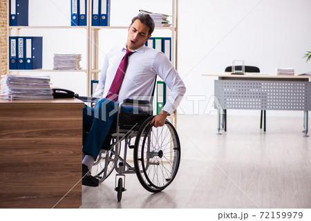 Young male employee after accident in wheel-chair at workplace Young male employee after accident in wheel-chair at workplace 72159979