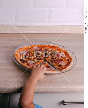The child tries to steal a slice of pizza from the box. Food delivery. Italian Cuisine. Banner 72160368