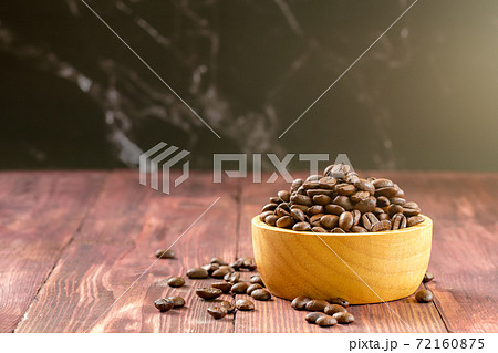 Coffee beans roasted in a wooden bowl on wooden background. 72160875