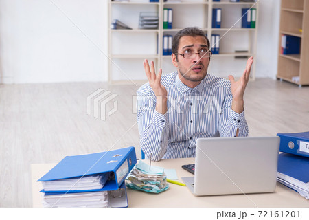 Young male bookkeeper calculating tax payments in the office 72161201