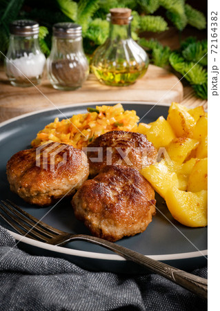 Meatballs  served with fired potatoes. 72164382