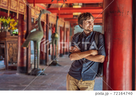 Man tourist in Temple of Literature in Hanoi in Southeast Asia, Vietnam. Temple of Confucius in Vietnamese capital. Vietnam reopens after coronavirus quarantine COVID 19 Man tourist in Temple of Literature in Hanoi in Southeast Asia, Vietnam. Temple of Confucius in Vietnamese capital. Vietnam reopens after coronavirus quarantine COVID 19 72164740