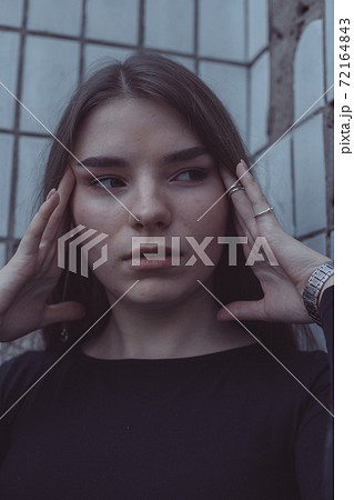 the girl driven into a corner in fear stands and looks 72164843