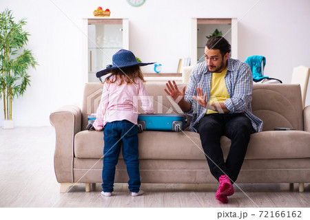 Young man and his small daughter preparing for the trip 72166162