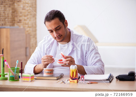 Young male dentist working in the clinic 72166959
