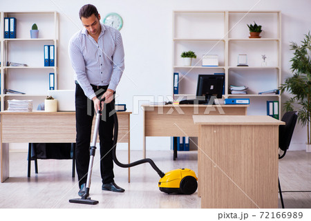 Young male employee cleaning office during pandemic 72166989