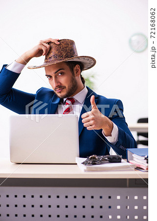 Young businessman cowboy working in the office Young businessman cowboy working in the office 72168062