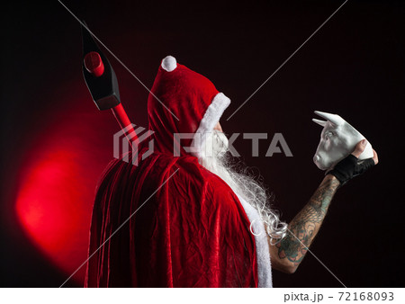 a man in a red Santa Claus Cape with an axe and a metal bull figurine symbol of the new year 2021 a man in a red Santa Claus Cape with an axe and a metal bull figurine symbol of the new year 2021 72168093