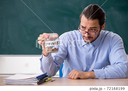 Young underpaid male teacher in the classroom 72168199