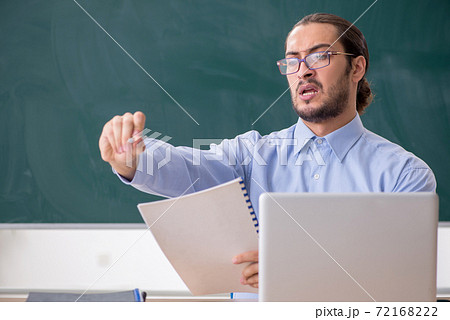 Young male teacher in the classroom in tele-education concept 72168222