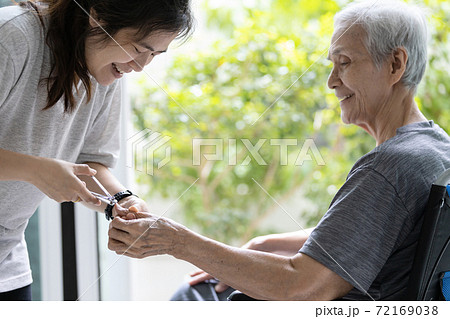 Happy smiling asian daughter cutting fingernail,manicure with nail clipper,help support to cleaning of finger nail for disabled senior mother in wheelchair,hygiene care,kindness,concern and gratitude Happy smiling asian daughter cutting fingernail,manicure with nail clipper,help support to cleaning of finger nail for disabled senior mother in wheelchair,hygiene care,kindness,concern and gratitude 72169038