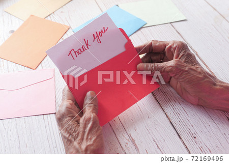 senior women's hand holding thank you letter , rear view senior women's hand holding thank you letter , rear view 72169496