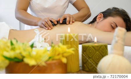 Young woman enjoying hot stone massage 72170004