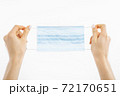 hands holding a mask, protective respiratory mask from the spread of the virus, on a white background 72170651
