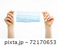 hands holding a mask, protective respiratory mask from the spread of the virus, on a white background 72170653