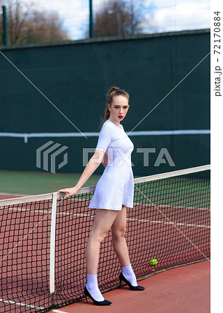Sexy girl tennis player holding tennis racket on the court. Young woman is playing tennis. Sexy girl tennis player holding tennis racket on the court. Young woman is playing tennis. 72170884