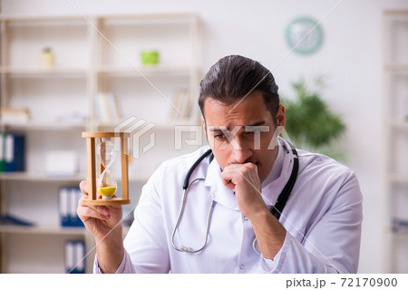 Young male doctor in time management concept Young male doctor in time management concept 72170900