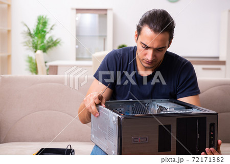 Young man repairing computer at home Young man repairing computer at home 72171382