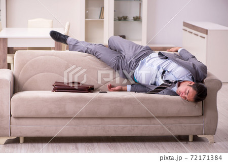 Tired young businessman coming home after working day Tired young businessman coming home after working day 72171384