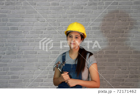 Technician woman ware yellow helmet with grey T-shirt and denim jeans Technician woman ware yellow helmet with grey T-shirt and denim jeans 72171462