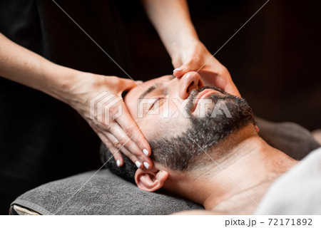 Man receiving facial massage at Spa salon Man receiving facial massage at Spa salon 72171892