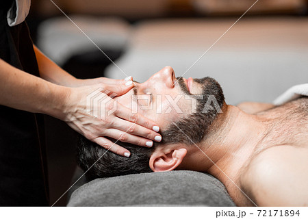 Man receiving facial massage at Spa salon Man receiving facial massage at Spa salon 72171894
