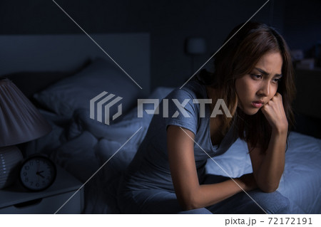 Depressed young Asian woman sitting in bed cannot sleep from insomnia. Depressed young Asian woman sitting in bed cannot sleep from insomnia. 72172191