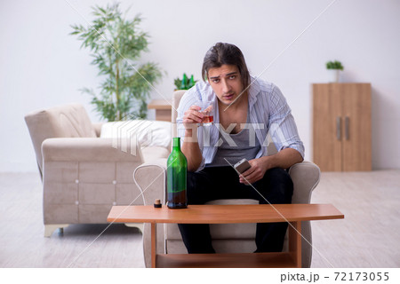 Young male alcoholic watching tv after party Young male alcoholic watching tv after party 72173055