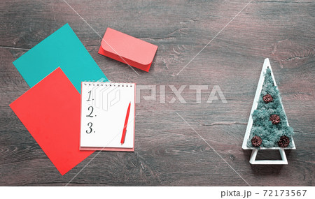 Numbered Christmas list on desk with Christmas tree Numbered Christmas list on desk with Christmas tree 72173567