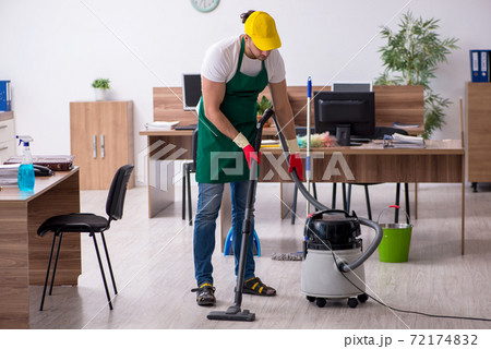 Young male contractor cleaning the office Young male contractor cleaning the office 72174832