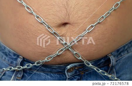 Big male belly coiled with chain. Fighting obesity concept 72176578
