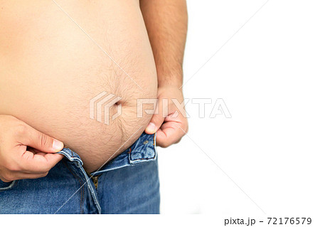 Fat man trying to button his jeans pant button because of his big belly 72176579