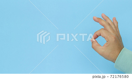 Male hand OK sign or gesture on blue background 72176580
