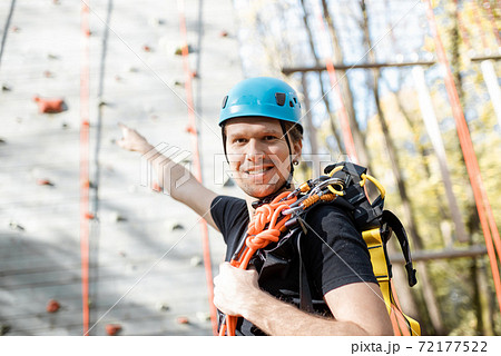 Well equipped man near the climbing wall outdoors 72177522