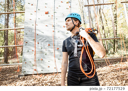 Well equipped man near the climbing wall outdoors 72177529