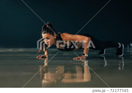 Strong woman doing push ups exercises indoors 72177585