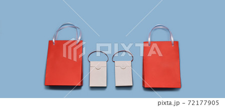 Paper shopping bags lined up in a horizontal row at the bottom. Two reds around the edges and two whites in the center. Paper shopping bags lined up in a horizontal row at the bottom. Two reds around the edges and two whites in the center. 72177905