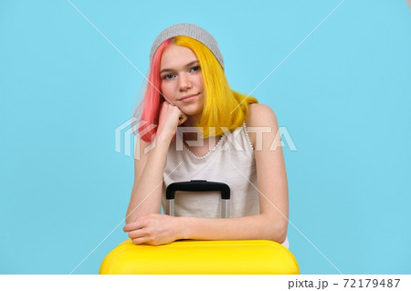 Young woman with yellow suitcase, smiling hipster teenager girl with colored hair 72179487